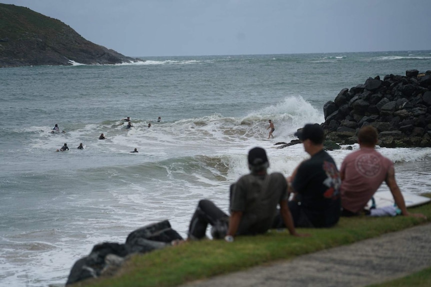 Surfers in greay, choppy water.