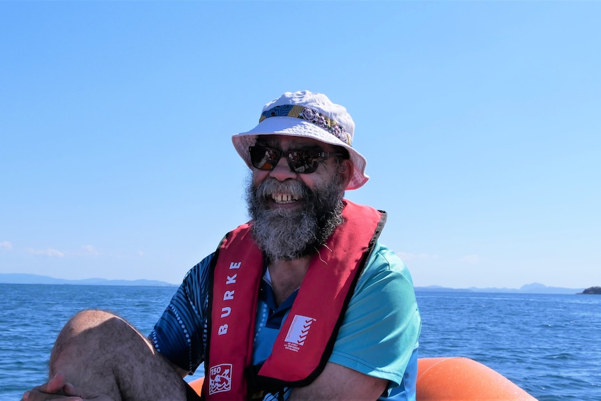 A man wearing a life jacket in a raft boat.