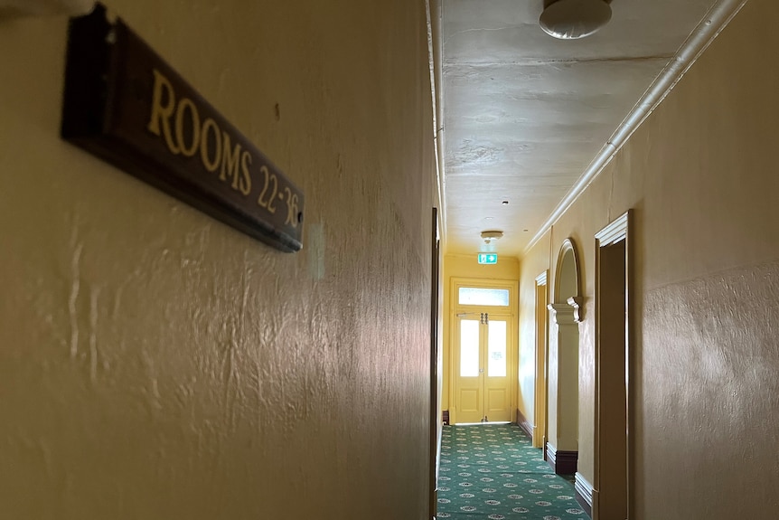 The hallway of the castle hotel, including a door and an exit sign