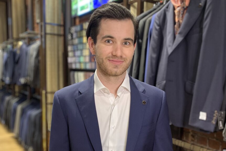 a man is in a suit store wearing a suit