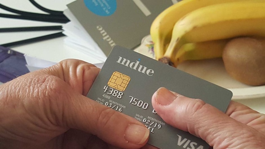 a grey debit card being held in someone's hands