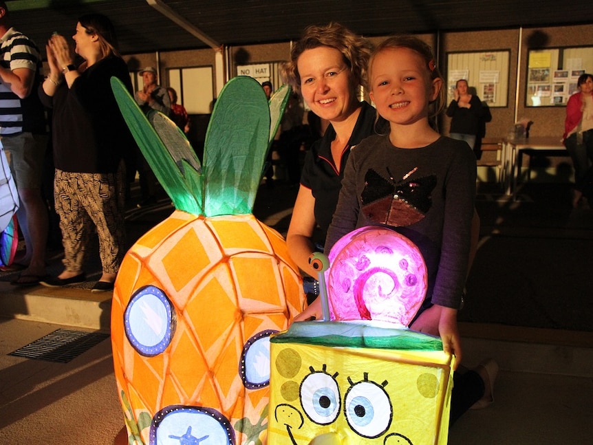 mother and child are proud of their sponge-bob squarepants lanterns