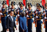 Manasseh Sogavare and Li Keqiang walk past an honour guard 