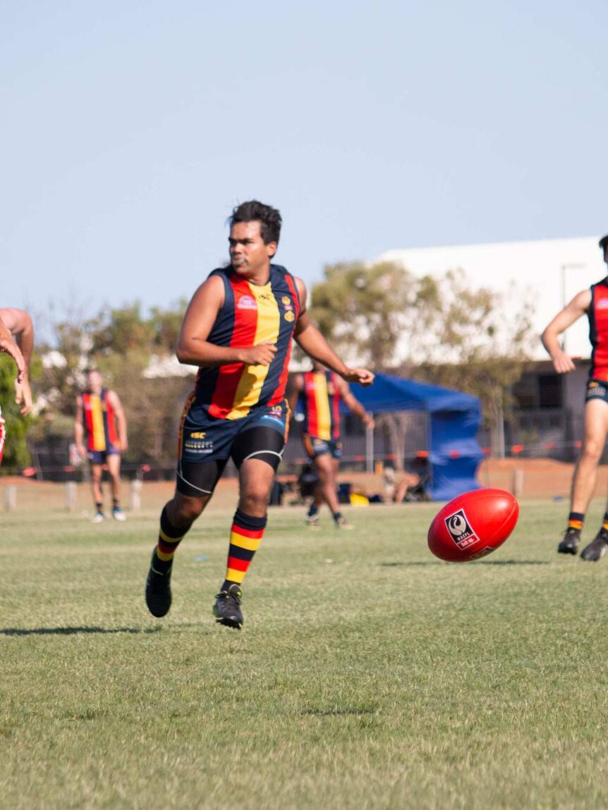 Footballers chasing after the ball during a Grand Final contest in Broome in 2019.