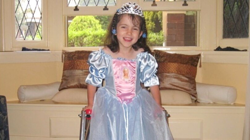 Hannah as a child dressed as a Disney princess, smiling at the camera.