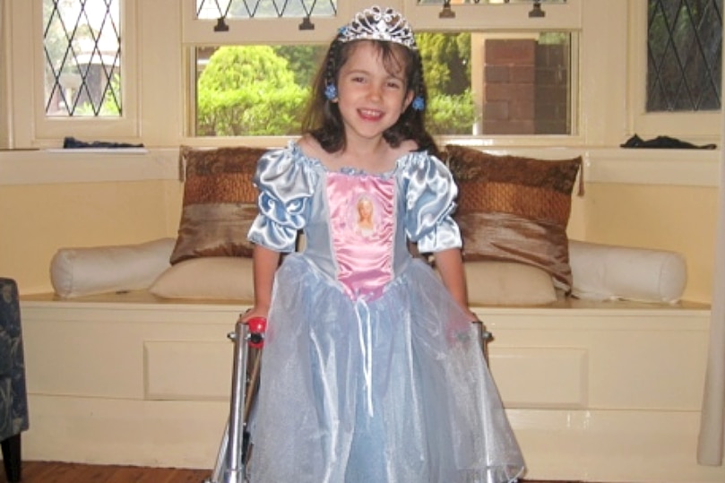 Hannah as a child dressed as a Disney princess, smiling at the camera.