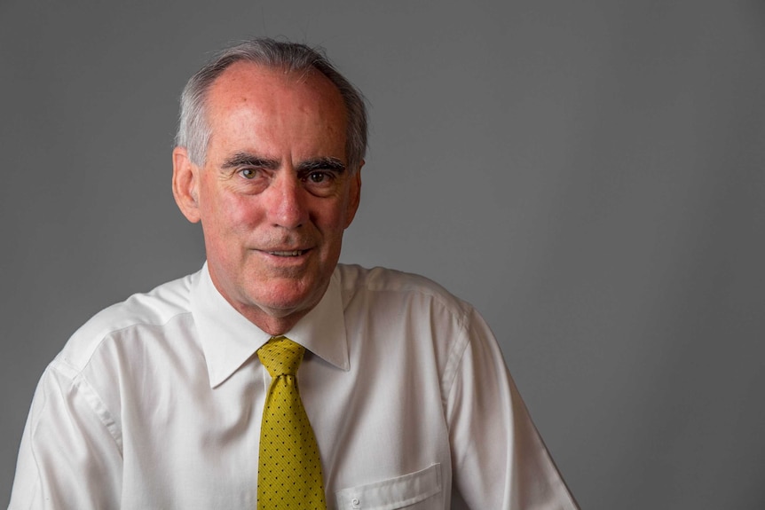 Greg Piper dressed in a white business shirt and yellow tie.