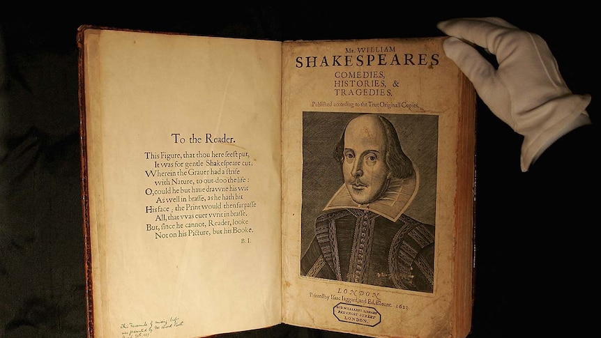 Person wearing gloves handles First Folio edition of Shakespeare's plays.