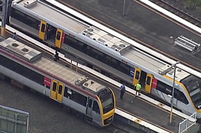 Aerial shot of two trains stopped at a train station, one with its doors open.