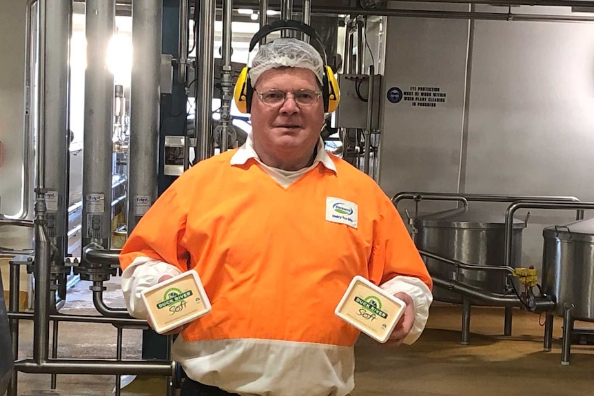 Spreyton dairy worker Adrian Wells in the Fonterra plant holding tubs of Duck River butter
