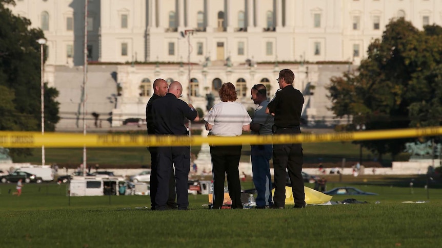 Police investigate the scene after a man set himself on fire at the National Mall on October 4, 2013 in Washington, DC.