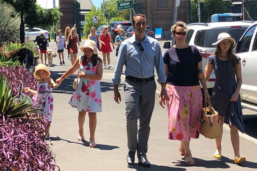 A man walking in the street with a woman and children