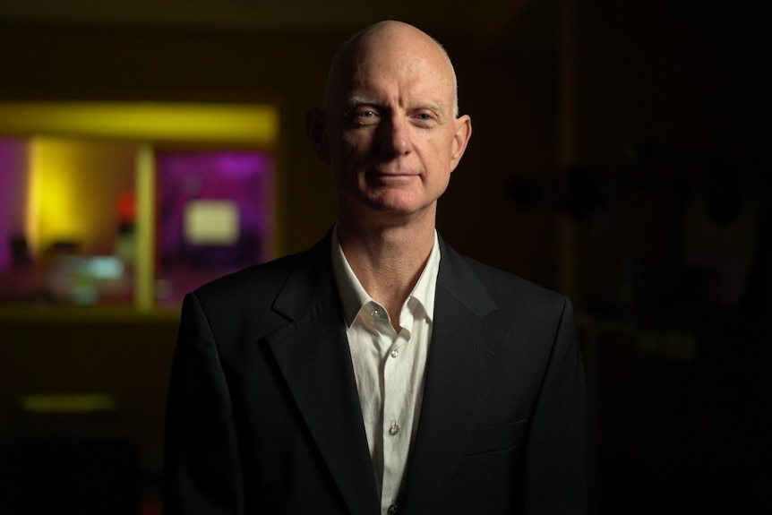 A man wearing a collared shirt and suit jacket.