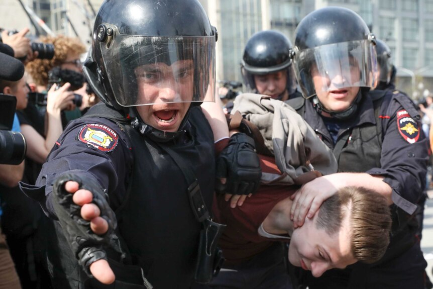 Russian police detain a protester at a demonstration against President Vladimir Putin