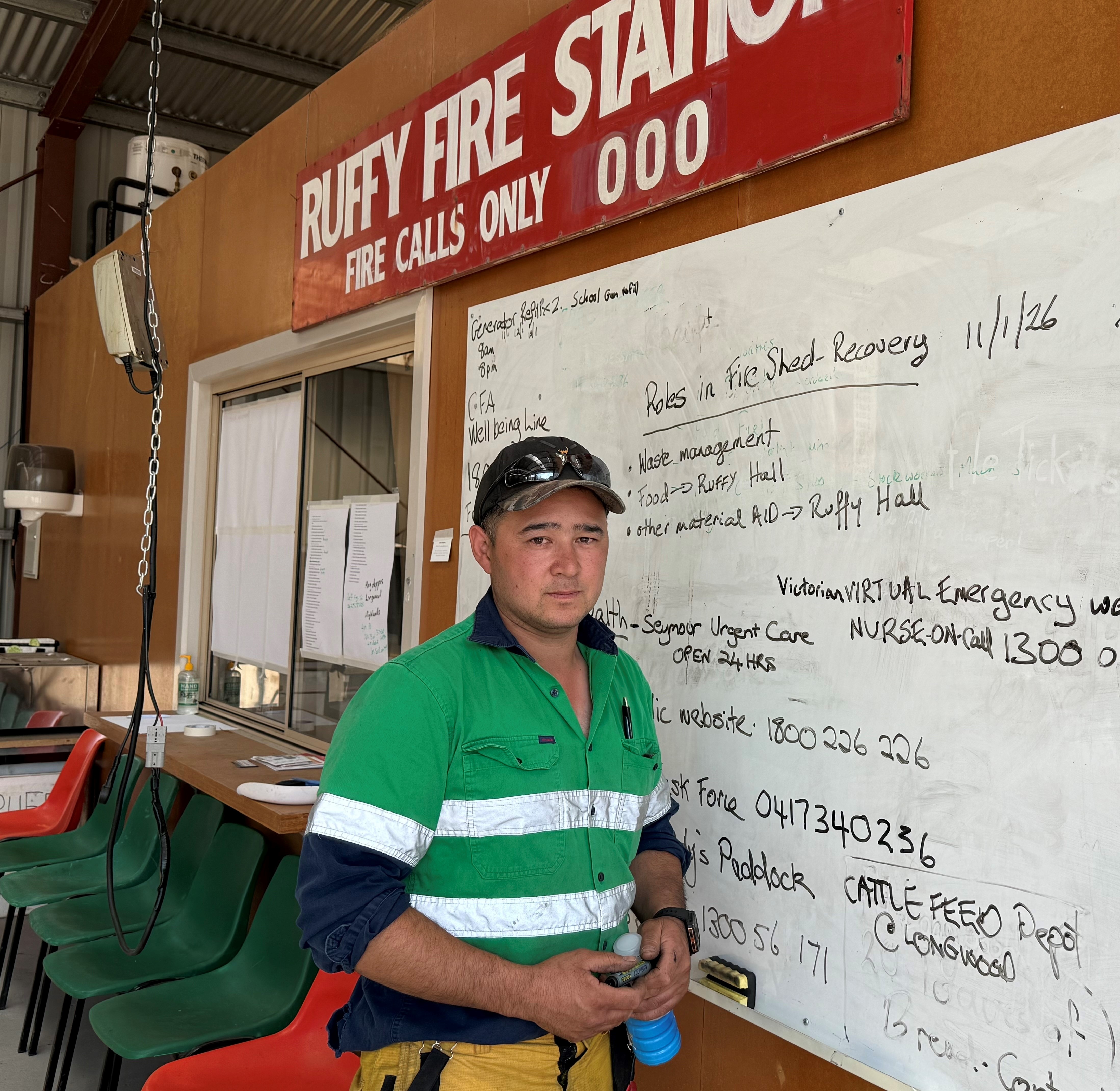 George Noye viste un uniforme verde de la CFA y está de pie junto a una pizarra.