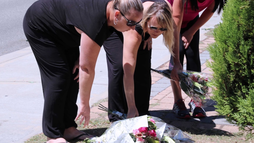 A group of women lay flowers on a footpath in Canning Vale after the death of a teenager hit by a car.