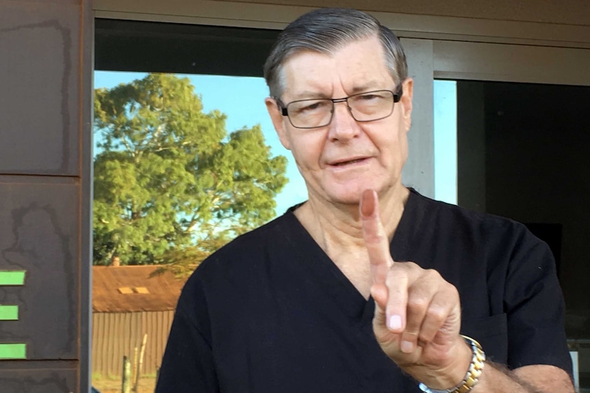 Port Hedland dentist Roger Higgins holding up a dust covered finger.