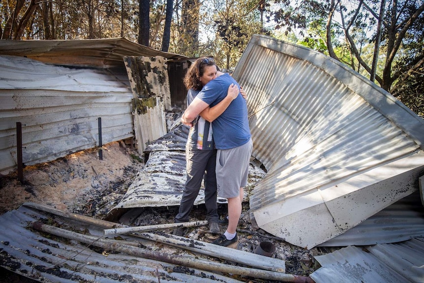 Lisa Groom and her son Luke Beyer stand in the wreckage of a shed on their property on Binna Burra Road.