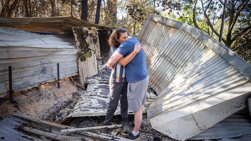 Lisa Groom and her son Luke Beyer stand in the wreckage of a shed on their property on Binna Burra Road.