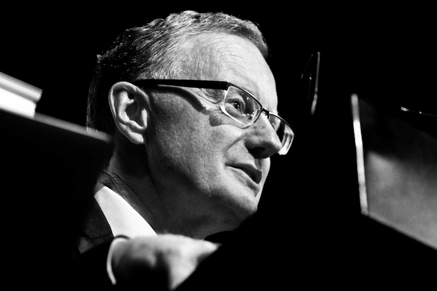 A black and white close up of a man wearing glasses