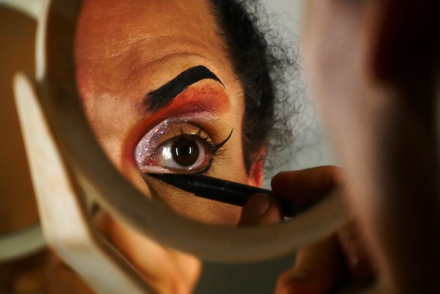 Close up of Roymata Holmes applying eye makeup