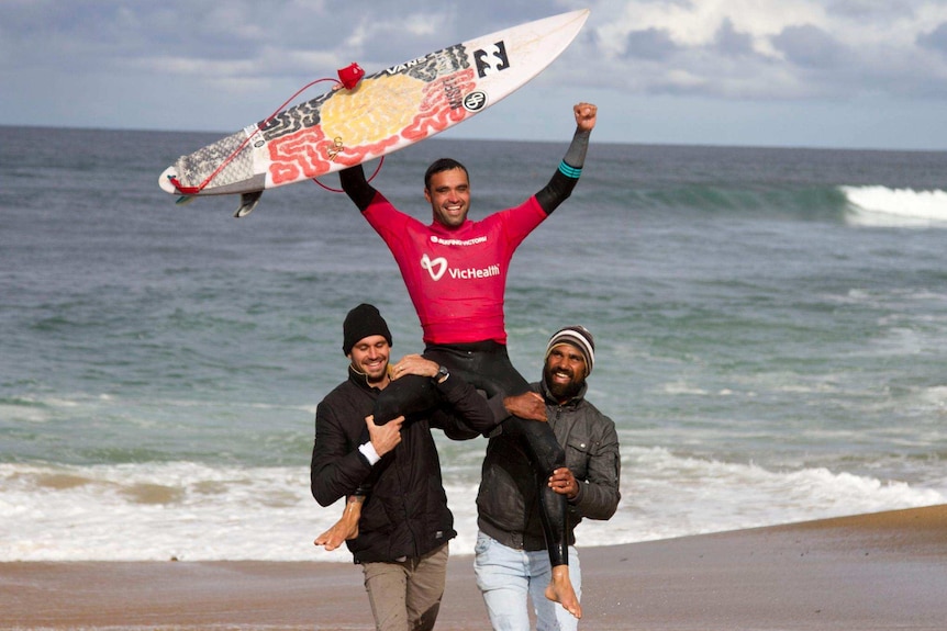 Otis Carey on the shoulders of two surfers after winning the 2017 Indigenous Surfing Titles at Bells Beach in Victoria.