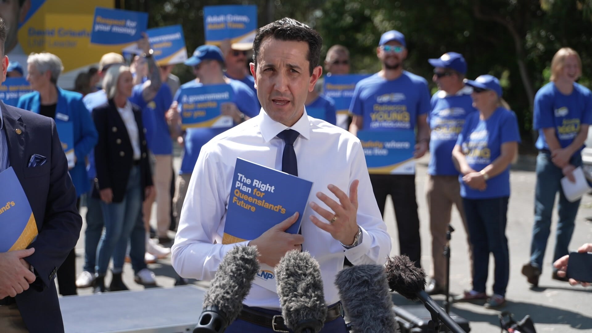野党党首のデイビッド・クリサフリ氏がマイクの列に向かって話している。