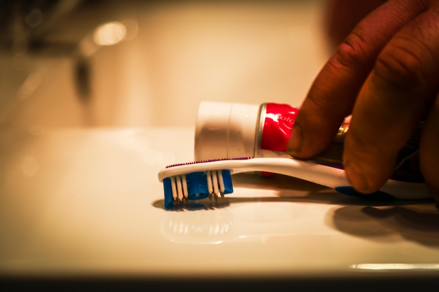 A close-up photograph of a toothbrush and toothpaste.