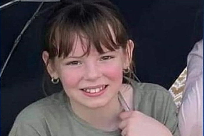 a young girl smiling and holding an umbrella