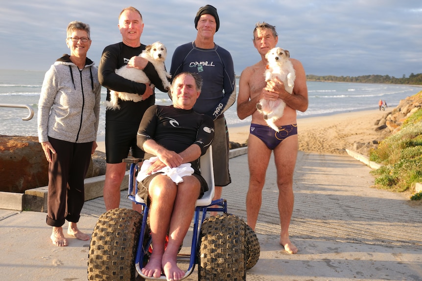 A happy group standing with ocean behind