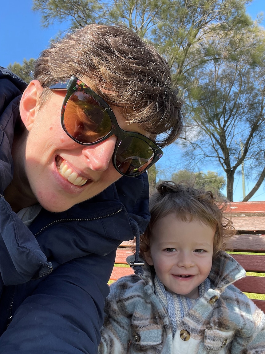 A selfie of a young mum with her toddler smiling at the camera