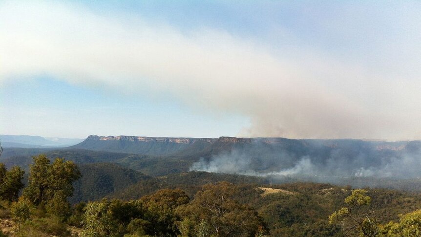 Smoke rises from a valley due to a hazard reduction burn in the Southern Highlands.