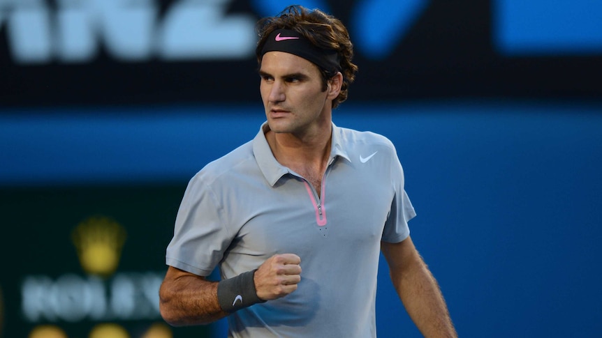 On top ... Roger Federer celebrates winning the first set