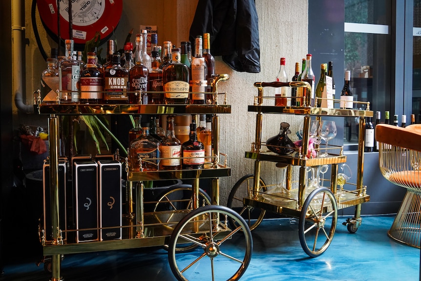 A gold-coloured trolley filled with bottles of whiskey