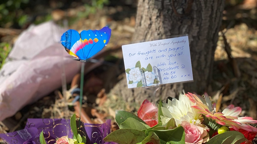 Flowers and notes laid underneath a tree