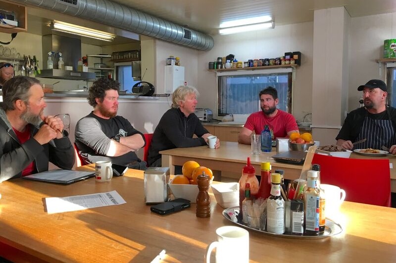Six members of the Wilkins crew waiting for dinner. They work on the Wilkins Runway in Antarctica. February 2017.