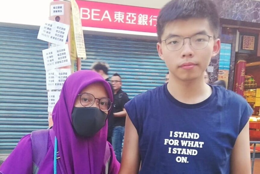 Photo shows Yuli in a purple hijab, face mask and glasses with Joshua Wong.