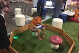 A boy uses a tablet to control the movement of a robotic ball.