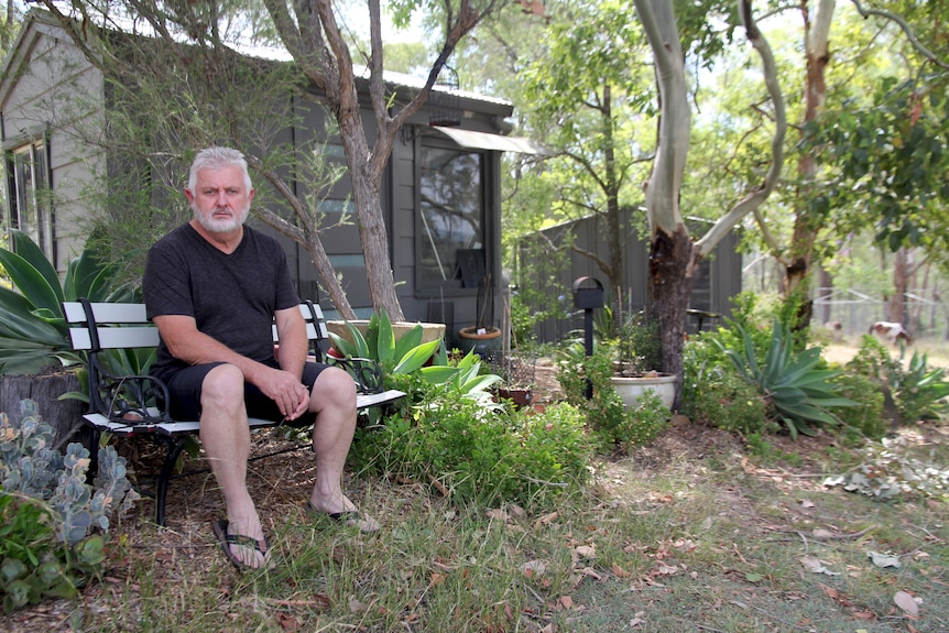 Peter Gogarty sits at a desk with papers and a pen in his hands looking at the camera.