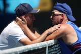 Two male tennis player embrace at the net after their quad wheelchair singles match at the Australian Open.