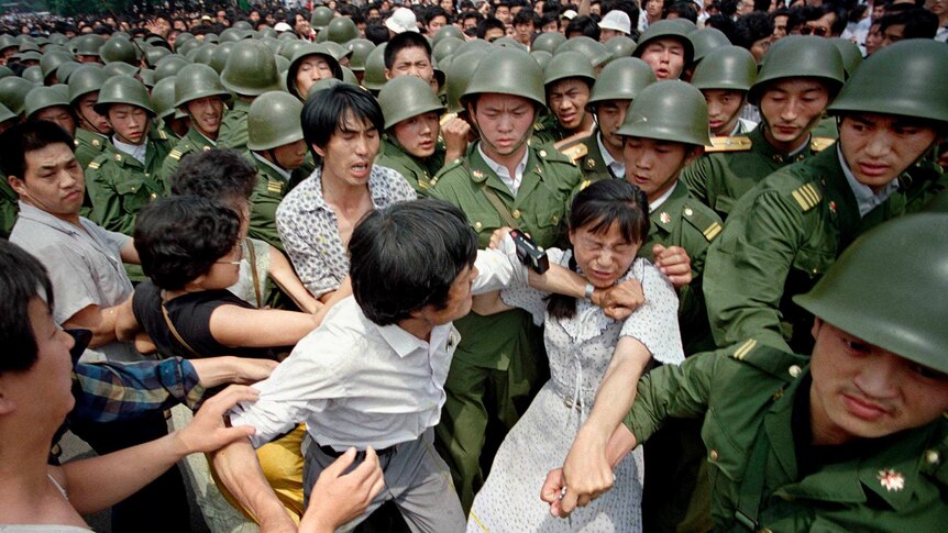 A young woman is caught between civilians and Chinese soldiers in Tiananmen Square on June 3, 1989.