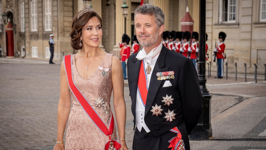 A man in a tux and a woman in a blush gown and tiara