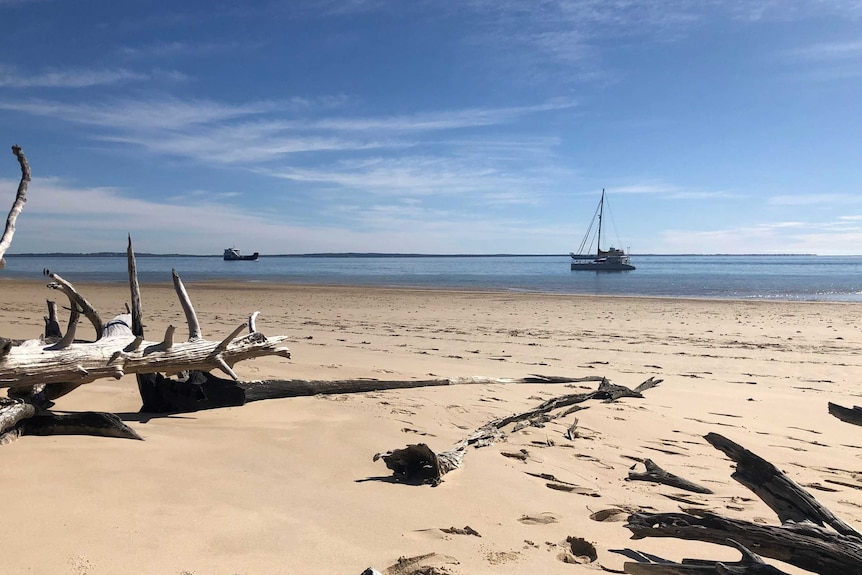 A barge travels towards Fraser Island on a sunny day.