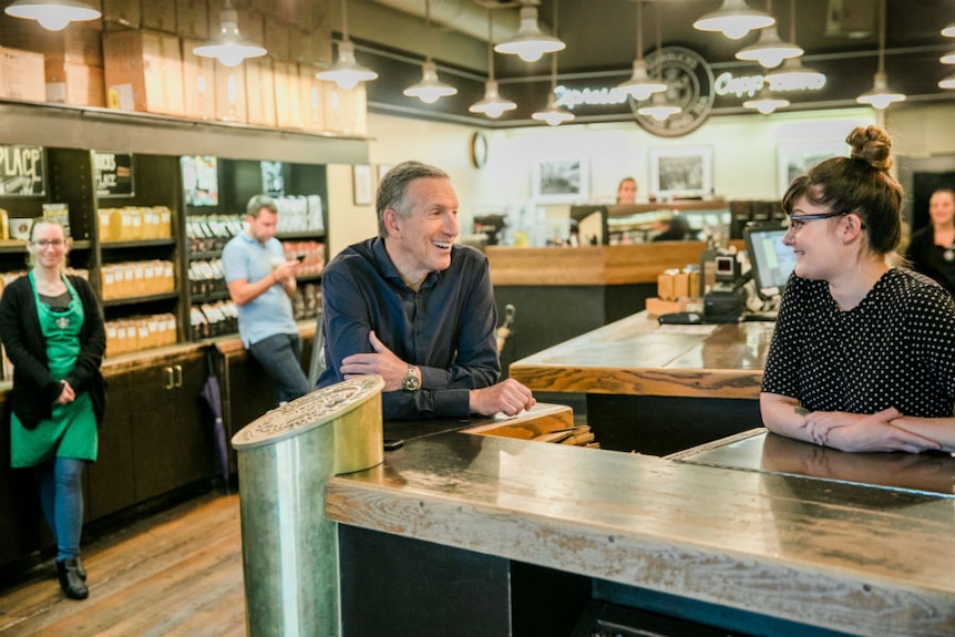 Howard Schultz talks to staff in a Starbucks cafe