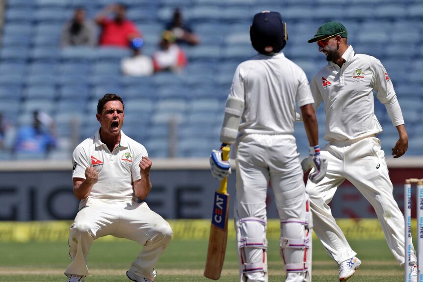 Steve O'Keefe celebrates the dismissal of India's Ajinkya Rahane on day two in Pune.