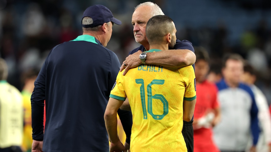 Graham Arnold embraces Aziz Behich after the Socceroos' loss to South Korea at the Asian Cup.