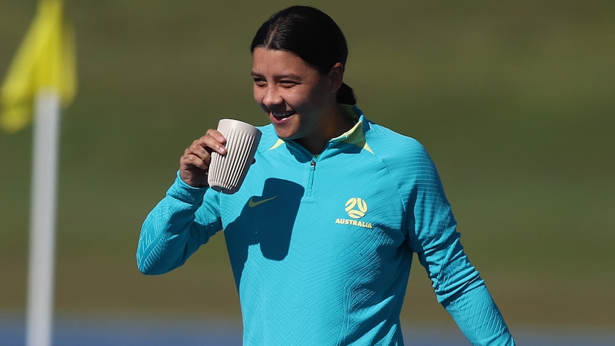 Sam Kerr drinks a coffee at a Matildas training session in Brisbane.