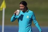 Sam Kerr drinks a coffee at a Matildas training session in Brisbane.