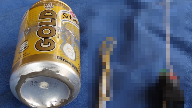 Can of Schweppes Gold soft drink and what appears to be a detonator and switch