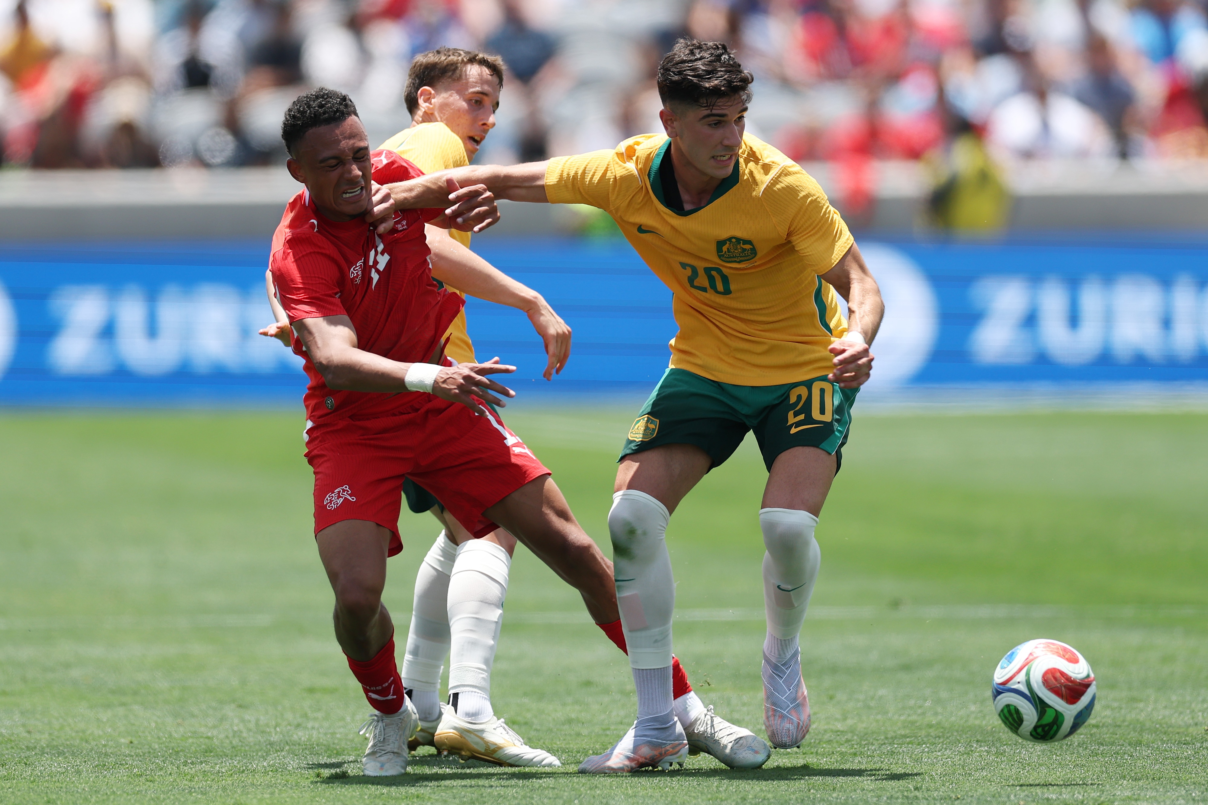 Cristian Volpato holds off a Switzerland defender